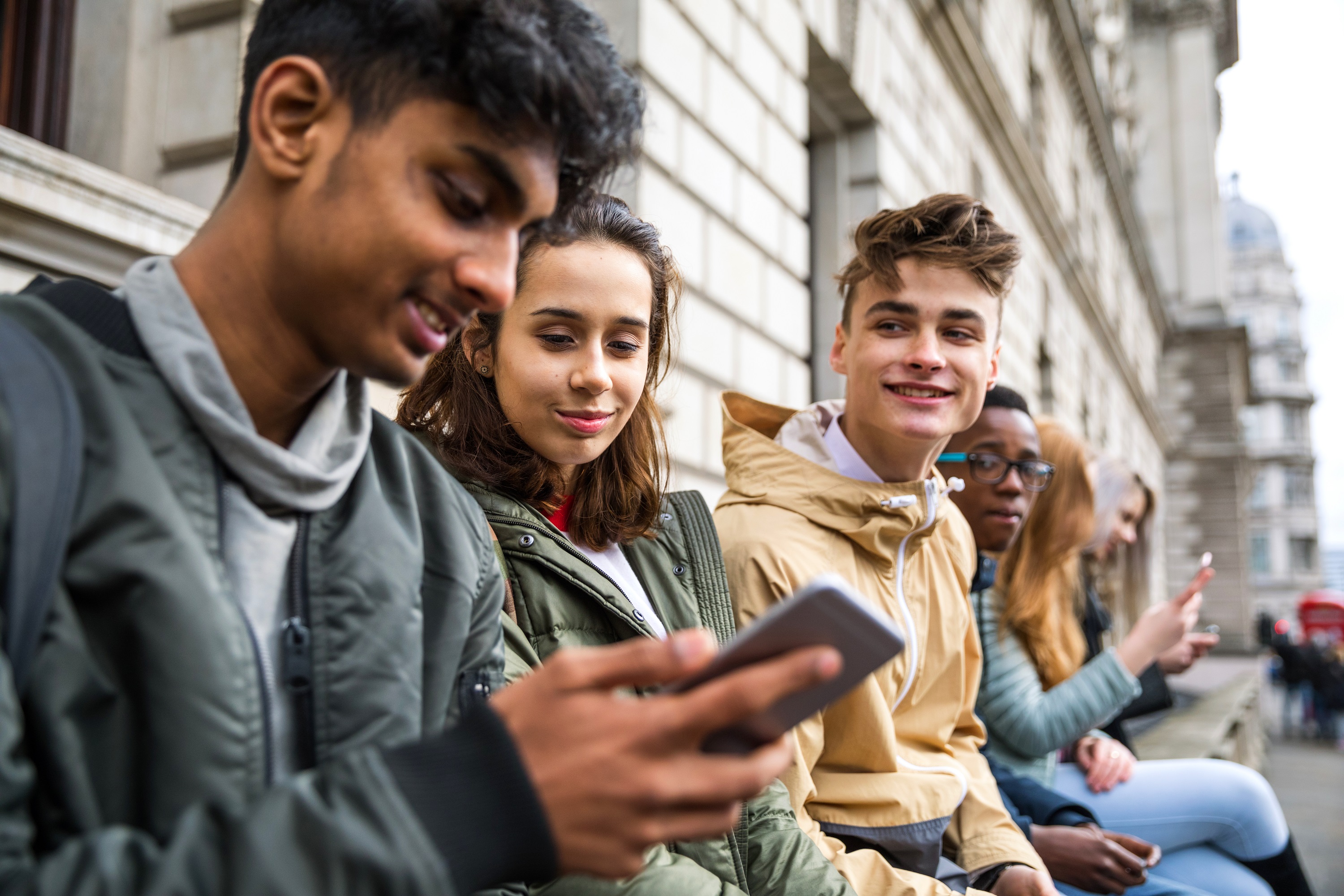 YE Trading Station – image of teenagers looking at mobile phones